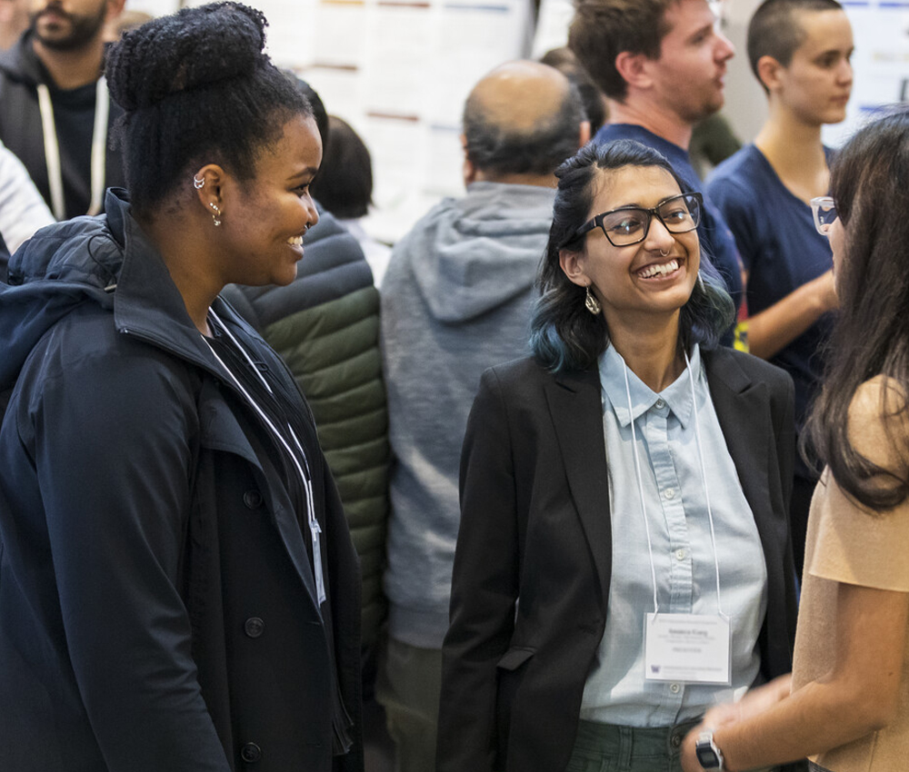 Three students interact at research symposium