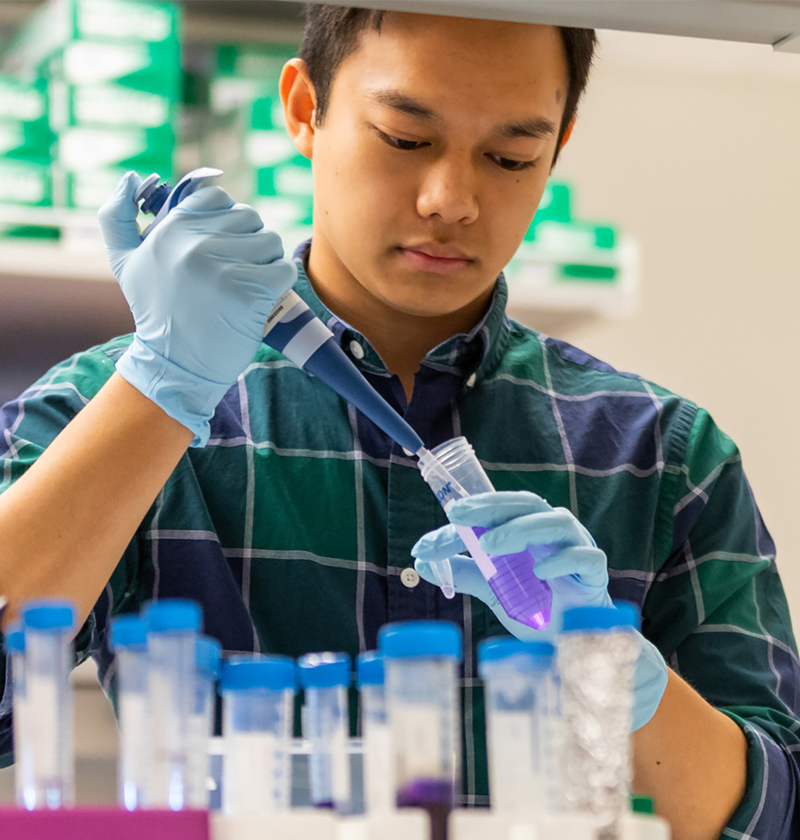 Male student pipetting in lab