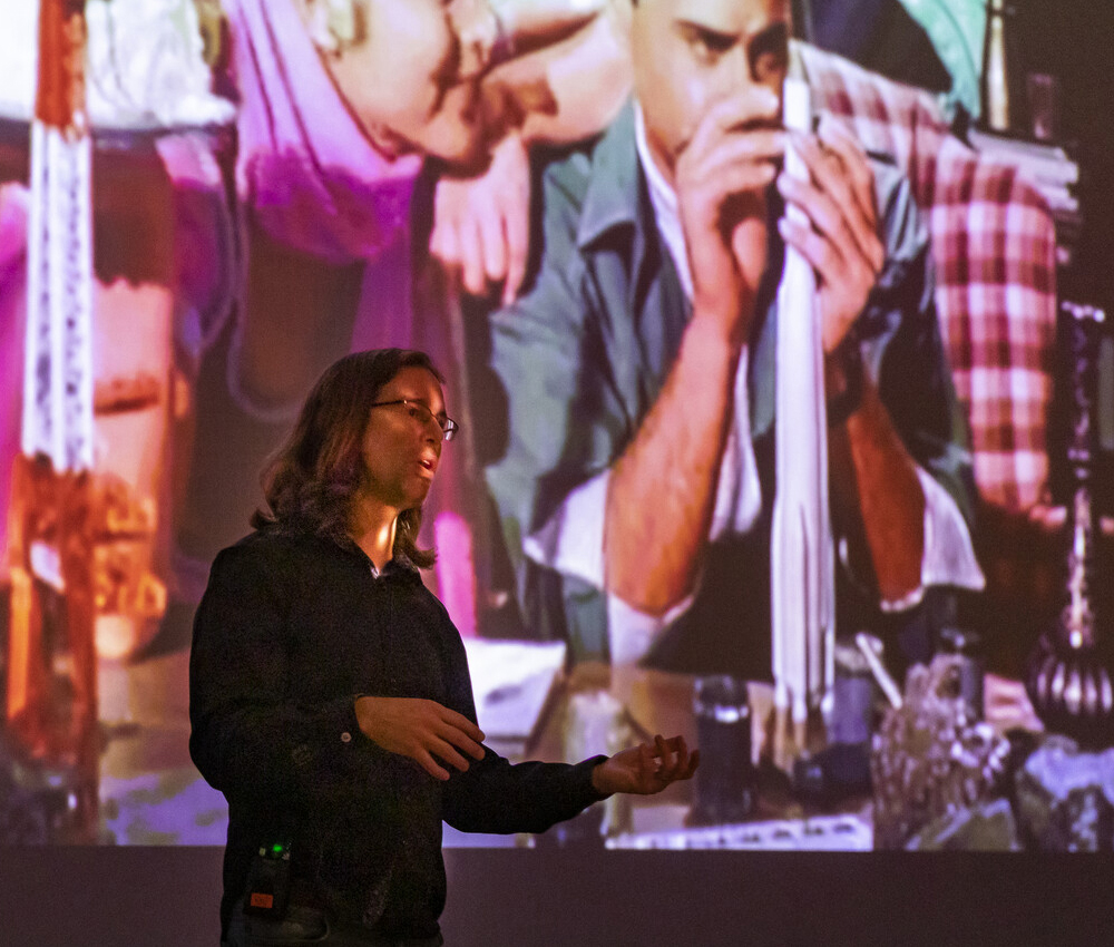 Male teacher standing in front of large screen