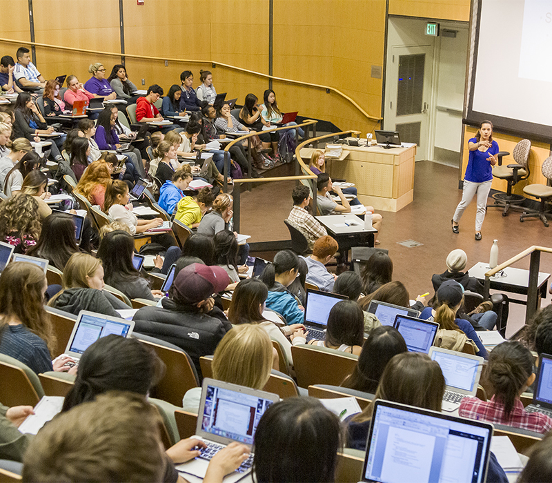 teacher talking in front of large lecture hall