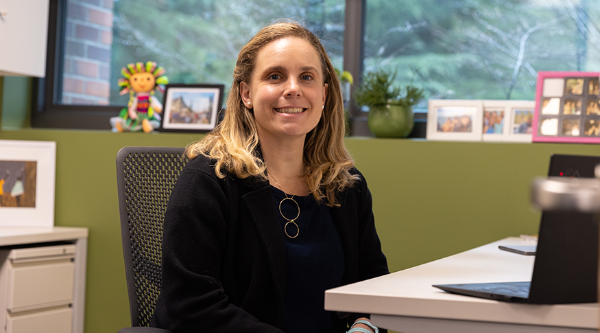 UW Psychology Professor Lucia Magis-Weinberg sitting at her desk in her office.
