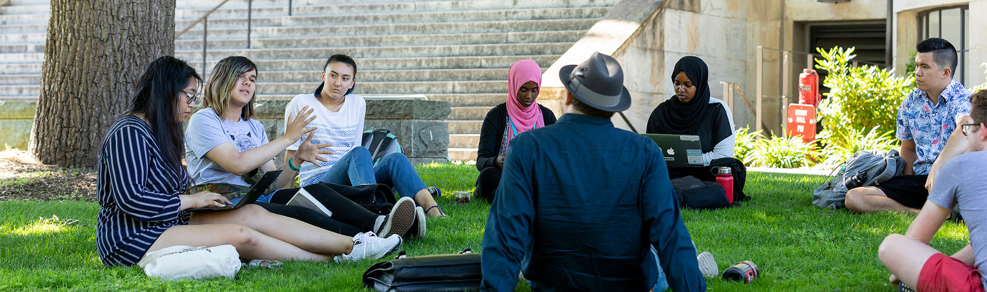 Students sitting outside on grass