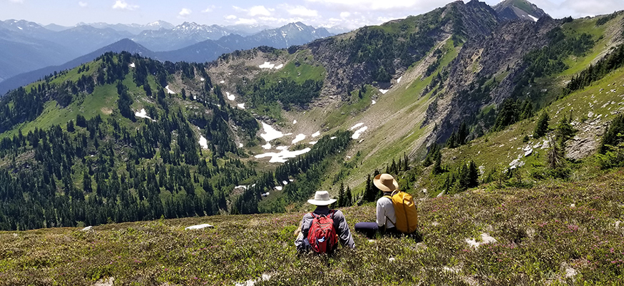 Ava Kloss-Schmidt sitting with David Giblin on Mt. Howard, with a sweeping view of the Cascades.