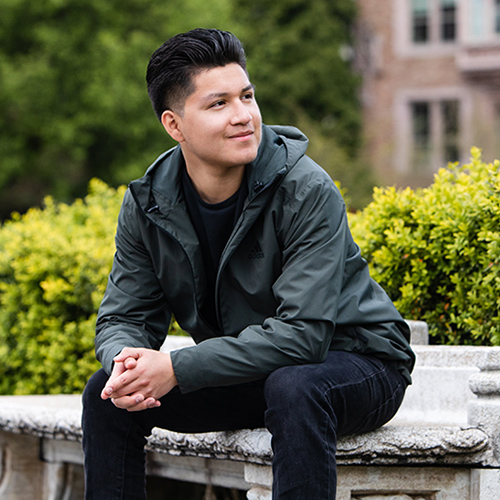 Will Sanchez sitting on a bench on the UW campus.