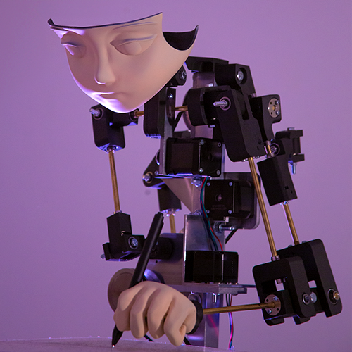A kinetic artwork with a mask-like face and a hand.